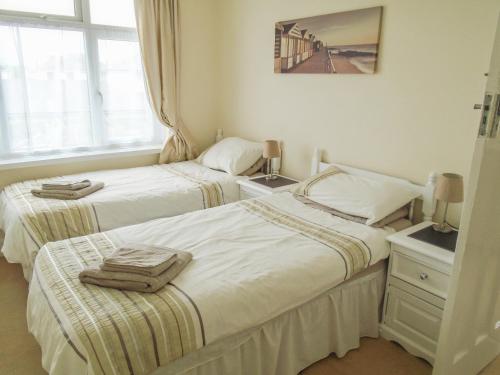 2 Einzelbetten in einem Zimmer mit Fenster in der Unterkunft 32 Cranleigh Close in Bournemouth