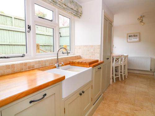 a kitchen with a sink and a window at Greenham Cottage in Chiselborough