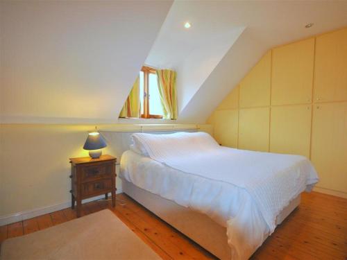 ein Schlafzimmer mit einem weißen Bett und einem Tisch mit einer Lampe in der Unterkunft The Courthouse in Preston