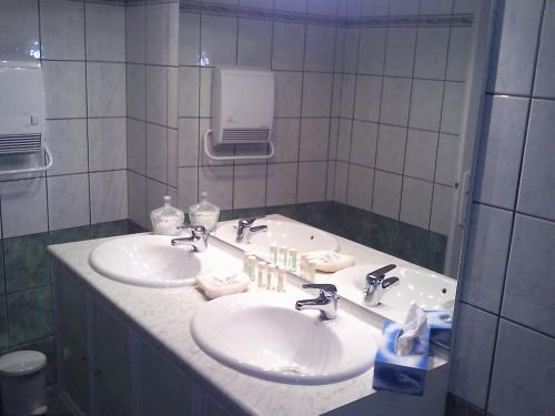 a bathroom with two sinks and a mirror at Le Chateau de Prauthoy in Prauthoy