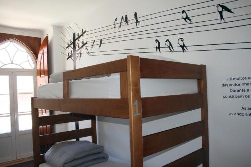 a bedroom with bunk beds and a wall with birds on wires at Hostel 2300 Thomar in Tomar
