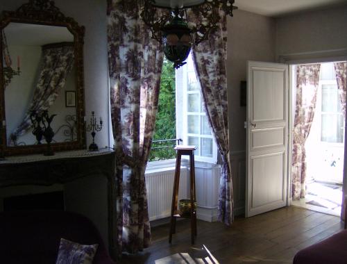 a living room with a window and a mirror at Le Chateau de Prauthoy in Prauthoy
