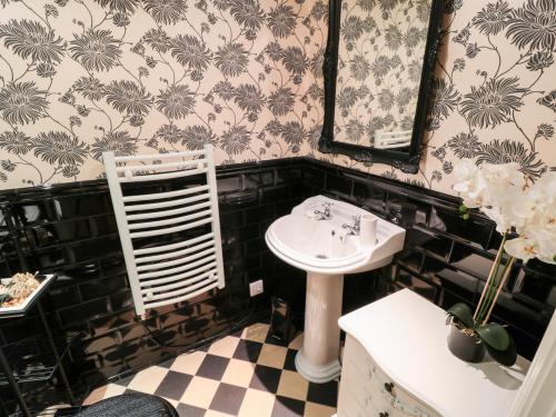 a bathroom with a sink and a mirror at Sneaton Hall Apartment 4 in Whitby
