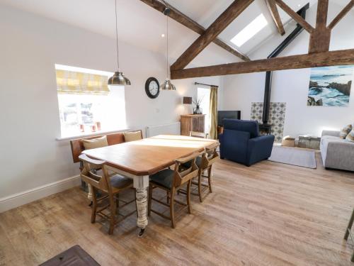 a dining room with a wooden table and chairs at The Granary in Holyhead