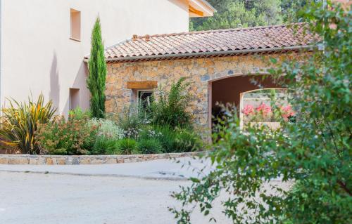 a stone house with a garden in front of it at The Originals City, Hôtel Les Bastides du Gapeau in Solliès-Toucas