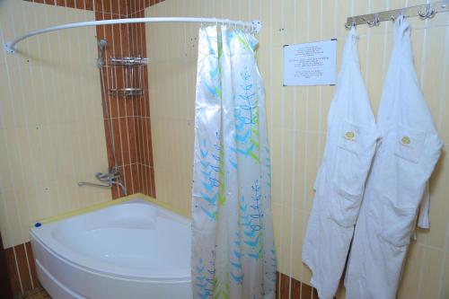 e bagno con servizi igienici e tenda per la doccia. di Dangara Hotel a Qo‘qon