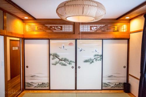 a room with glass doors with birds on them at RUSUTSU HOLIDAY CHALET in Rusutsu