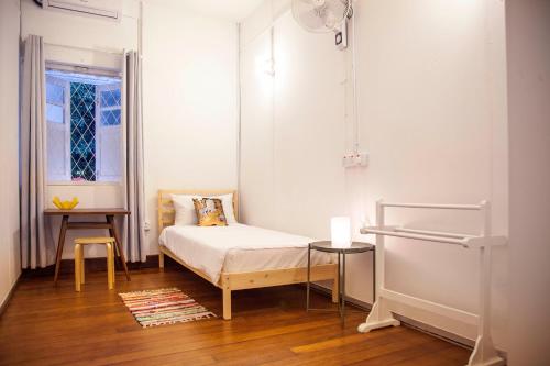 a small bedroom with a bed and a window at YWCA Kuala Lumpur in Kuala Lumpur