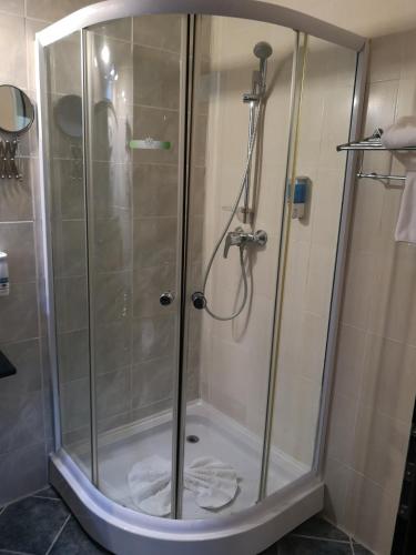 a shower with a glass door in a bathroom at Hotel ZEN-Aeroport in Craiova
