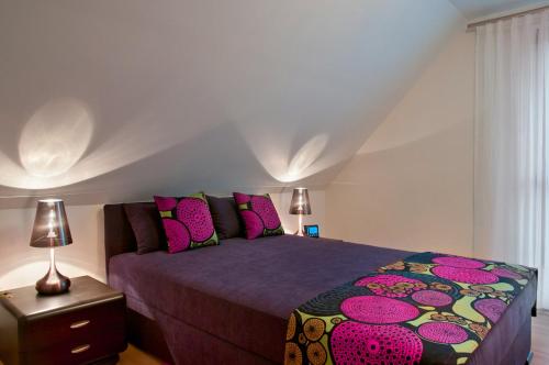 a bedroom with a large bed with pink pillows at Domki Wioska Rybacka in Hel