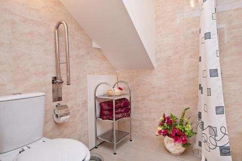 a bathroom with a toilet and flowers in it at Domki Wioska Rybacka in Hel