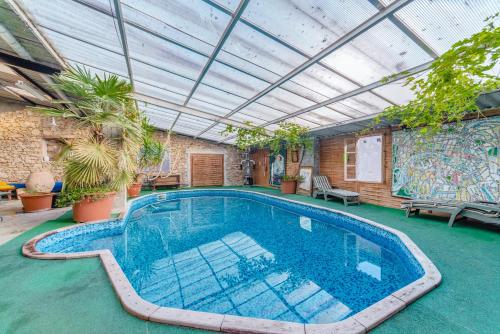an indoor swimming pool with a roof with plants at L'Élassier in Saint-Priest-sous-Aixe