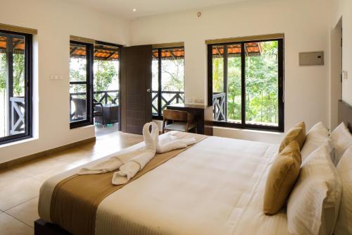 a large bedroom with a large bed with windows at The Serenity Resort in Tariyod
