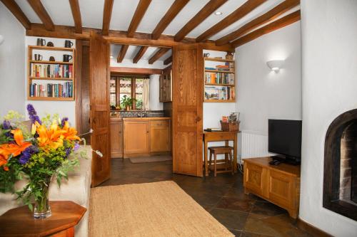 a kitchen with a vase of flowers on a table at Aslan in Chipping Norton