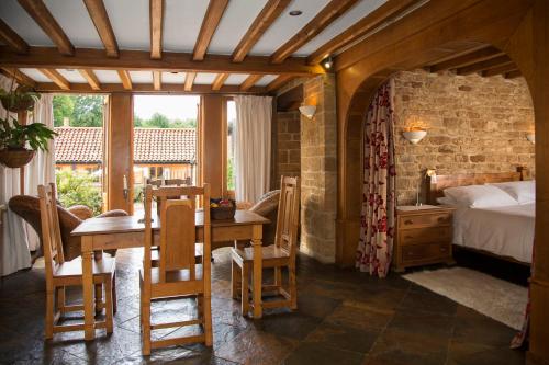 a bedroom with a bed and a table and chairs at Aslan in Chipping Norton
