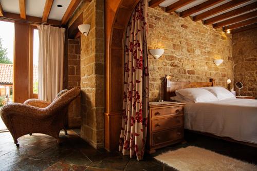 a bedroom with a bed and a chair in a room at Aslan in Chipping Norton
