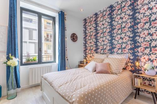 um quarto com uma cama com uma parede floral em Les Cocons Emeraude et Fleuri em Lyon