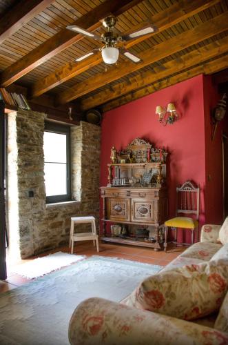 a living room with a red wall with a dresser at Casa de Campo dos Távoras in Mirandela
