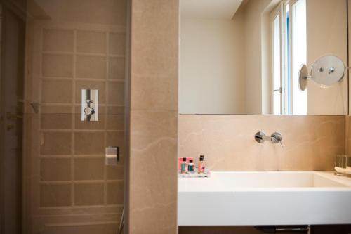 a bathroom with a shower with a sink and a mirror at Giardini Mon Plaisir in Trapani