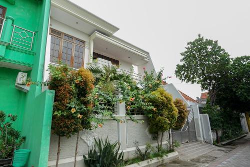 uma casa com uma cerca com flores em Bumi Banyu Bening Syariah by ecommerceloka em Surabaya