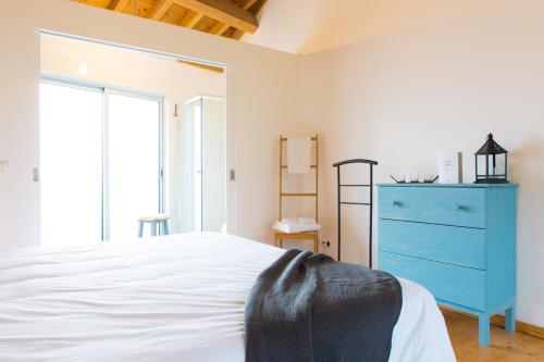 a bedroom with a blue dresser and a bed at Casa dos Caldeiras in Lajes do Pico