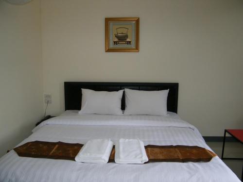 a bed with two white towels on top of it at Fundee 1 Mansion in Ubon Ratchathani