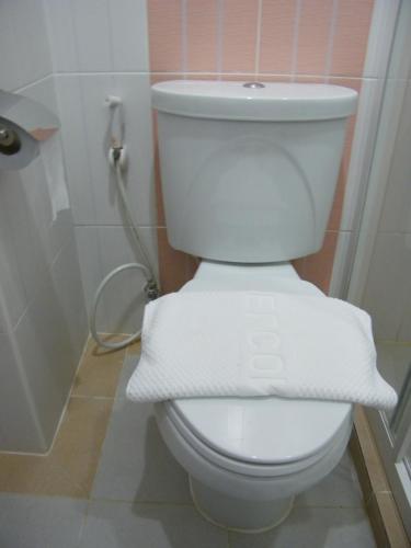 a bathroom with a toilet with two towels on it at Fundee 1 Mansion in Ubon Ratchathani