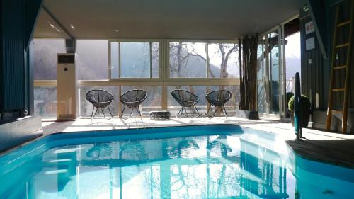 a swimming pool with chairs in a house at Le Solayan in Couledoux
