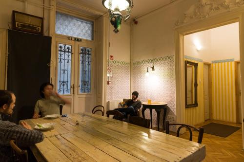 a group of people sitting around a table in a room at Baroque Hostel & Coworking in Budapest