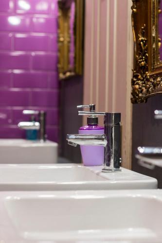 a bathroom with two sinks and a faucet at Baroque Hostel & Coworking in Budapest