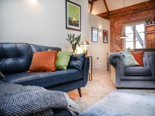 a living room with a couch and two chairs at Padstow Escapes - The Long Room Luxury Apartment in Padstow
