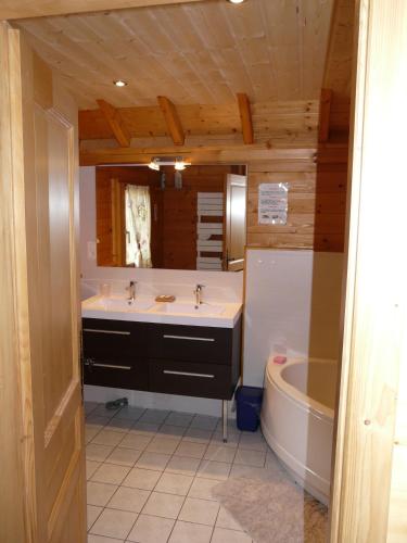 une salle de bain avec une baignoire et un lavabo et une baignoire dans l'établissement Chalet Les Sapins Argentés, à Gérardmer