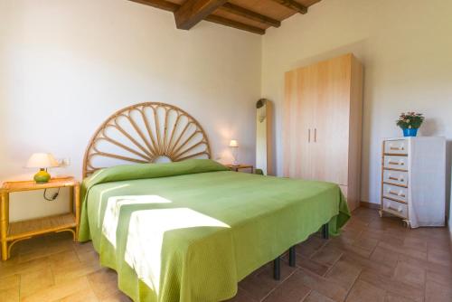 ポルトフェッラーイオにあるAppartamenti Bellavista by HelloElbaのベッドルーム(緑のベッド1台、ドレッサー付)
