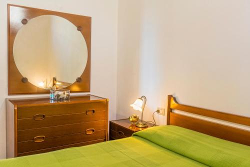 a bedroom with a bed and a dresser with a mirror at Appartamenti Bellavista - HelloElba in Portoferraio