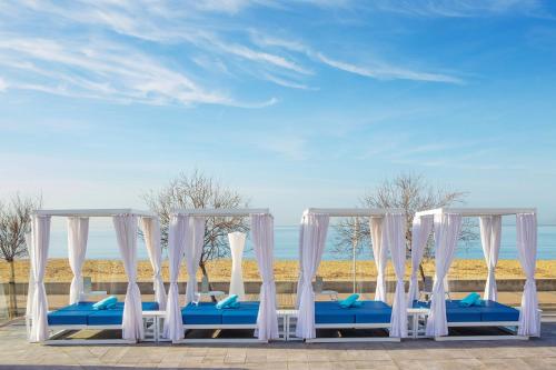 a row of white canopy beds on a beach at Aparthotel Fontanellas Playa in Playa de Palma