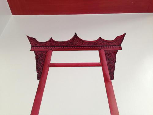 a red wooden frame on top of a white wall at CHERN Bangkok in Bangkok