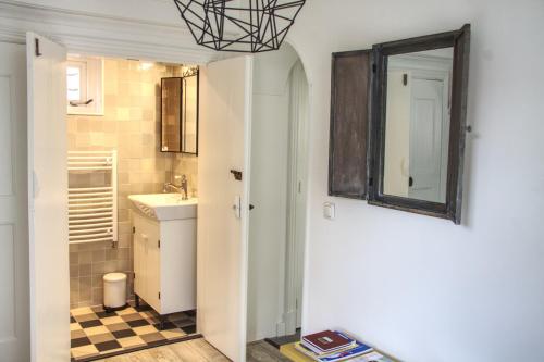 a bathroom with a sink and a mirror at Huisje de Eersteling in Moddergat