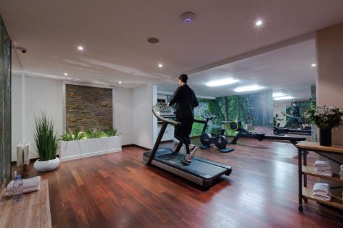 a man walking on a treadmill in a gym at Hotel de Berny in Antony