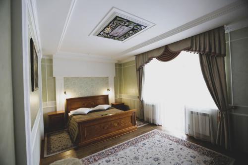 a bedroom with a bed and a large window at Solnichnaia Dolyna in Polyana