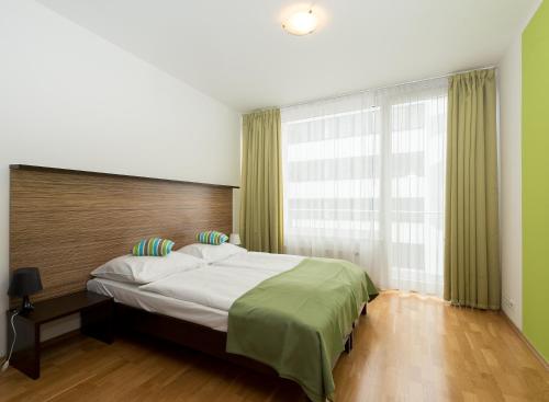 a bedroom with a large bed and a large window at Aparthotel Angel in Prague