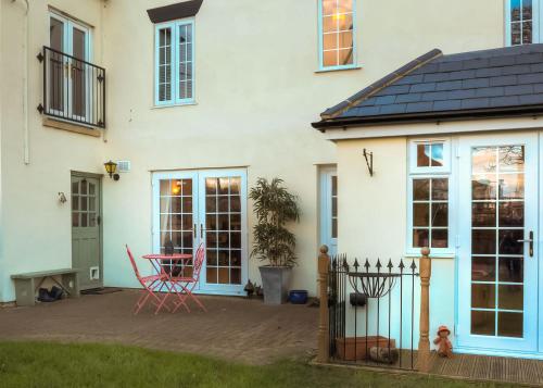 a white house with a patio in front of it at House on the Corner B&B in Didcot