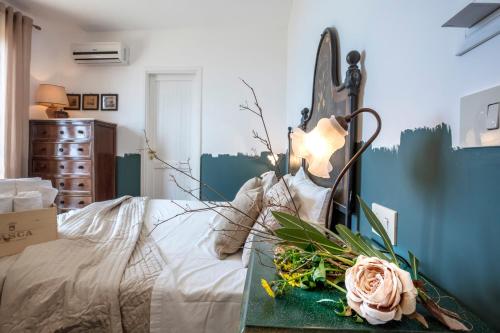 a bedroom with a bed with flowers on a table at Hotel Pocho in San Vito lo Capo