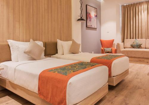 a hotel room with two beds and a couch at Centre Point Navi Mumbai in Navi Mumbai