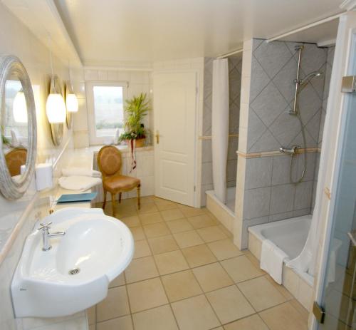 a bathroom with a sink and a shower and a tub at Landsitz Kapellenhöhe, Hotel Garni in Wiedenbrügge