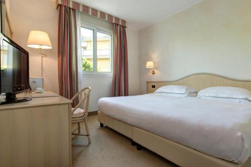 a hotel room with a bed and a desk with a computer at Park Hotel Brasilia in Lido di Jesolo
