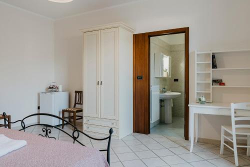 ヴィニャカストリジにあるIL MELOGRANO B&Bのベッド、テーブル、キッチンが備わる客室です。