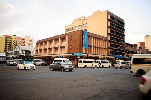 a busy city street with cars parked in front of a building at Bayside Hotel 97 Russell Street in Durban