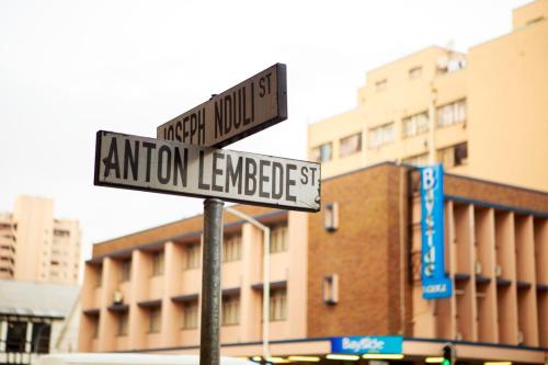 two street signs on a pole in a city at Bayside Hotel 97 Russell Street in Durban