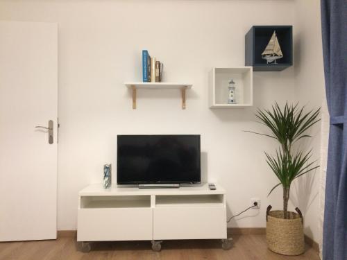 a living room with a tv on a white cabinet at Simply@Home in Setúbal