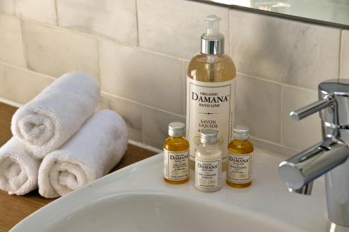 a bathroom sink with towels and a bottle of alcohol at The Swallows Rest Bed & Breakfast in Brigstock